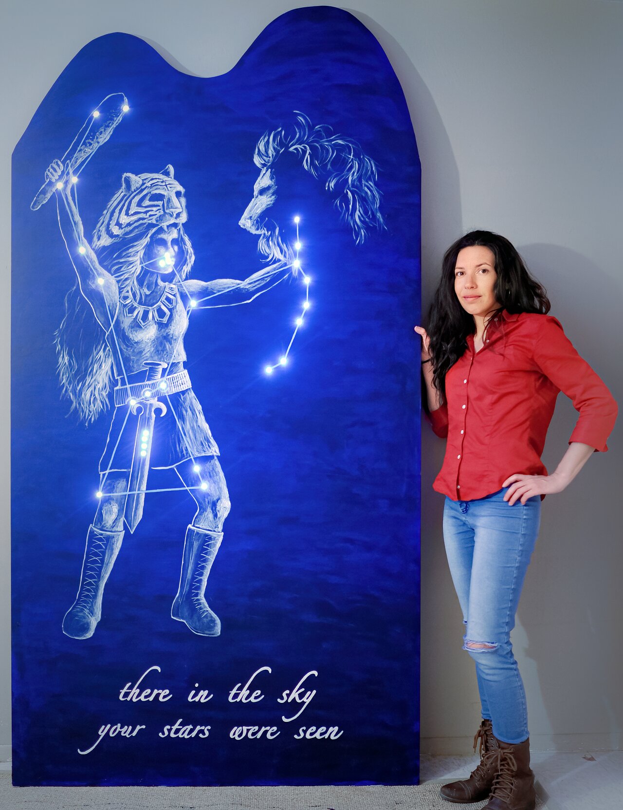 Stéphanie Juneau next to her artwork of Orion as "the huntress"